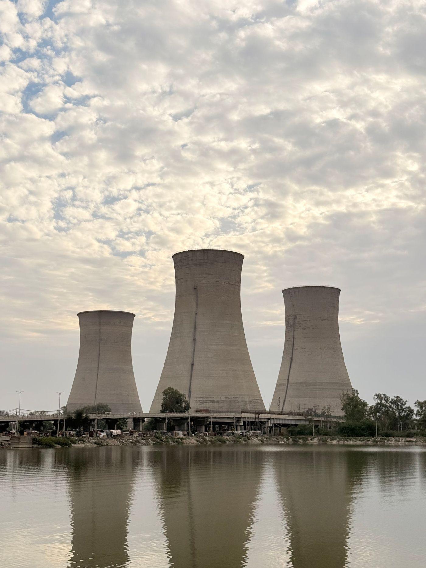 Industrial cooling towers standing over the still surface of a lake
